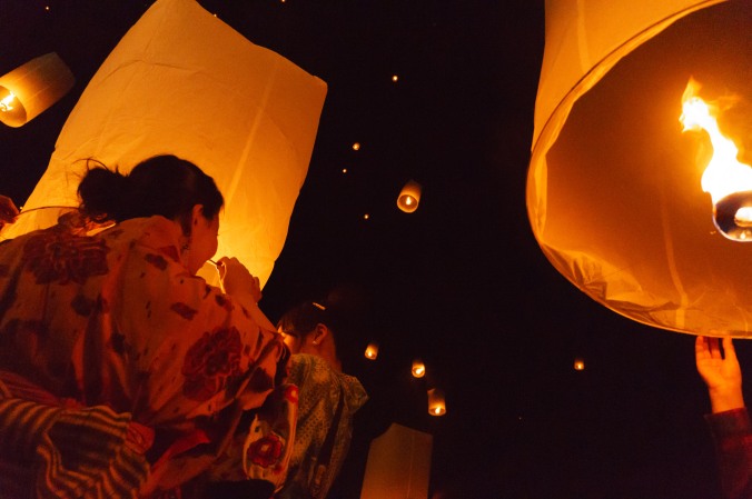 A Japanese woman wears a kimono and lights a sky lantern during a New Year's Eve 2014 celebration in Chiang Mai, Thailand